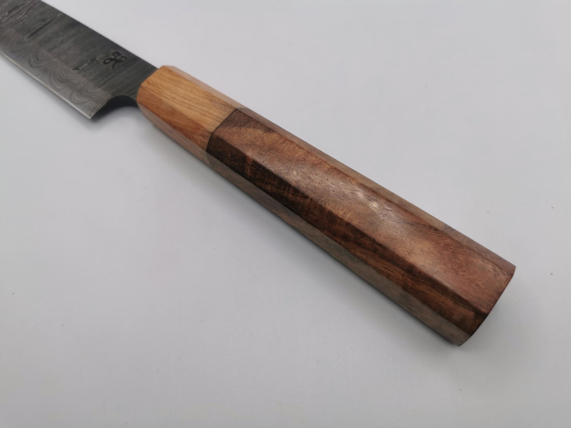 Manche du couteau de chef Le Valensola en bois d'olivier clair et bois de rose foncé, détail de la prise en main