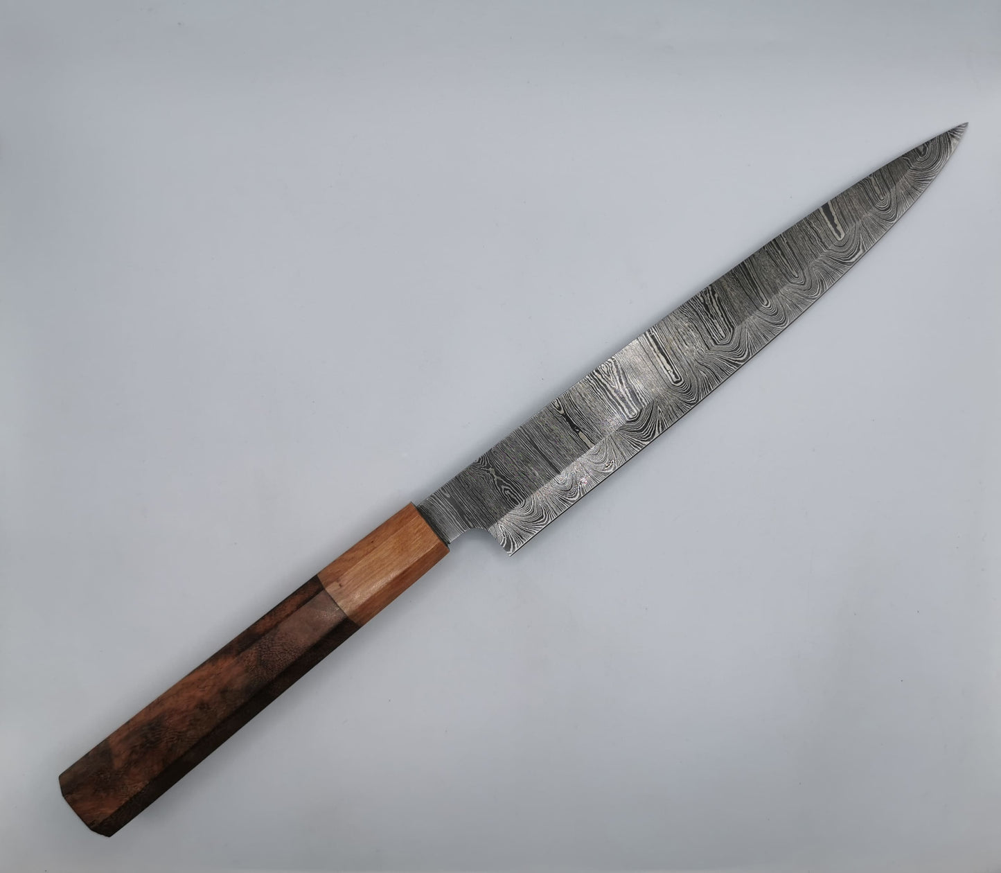 Couteau de chef artisanal Le Valensola, vue complète de la lame en acier damas et du manche bicolore olivier et rose