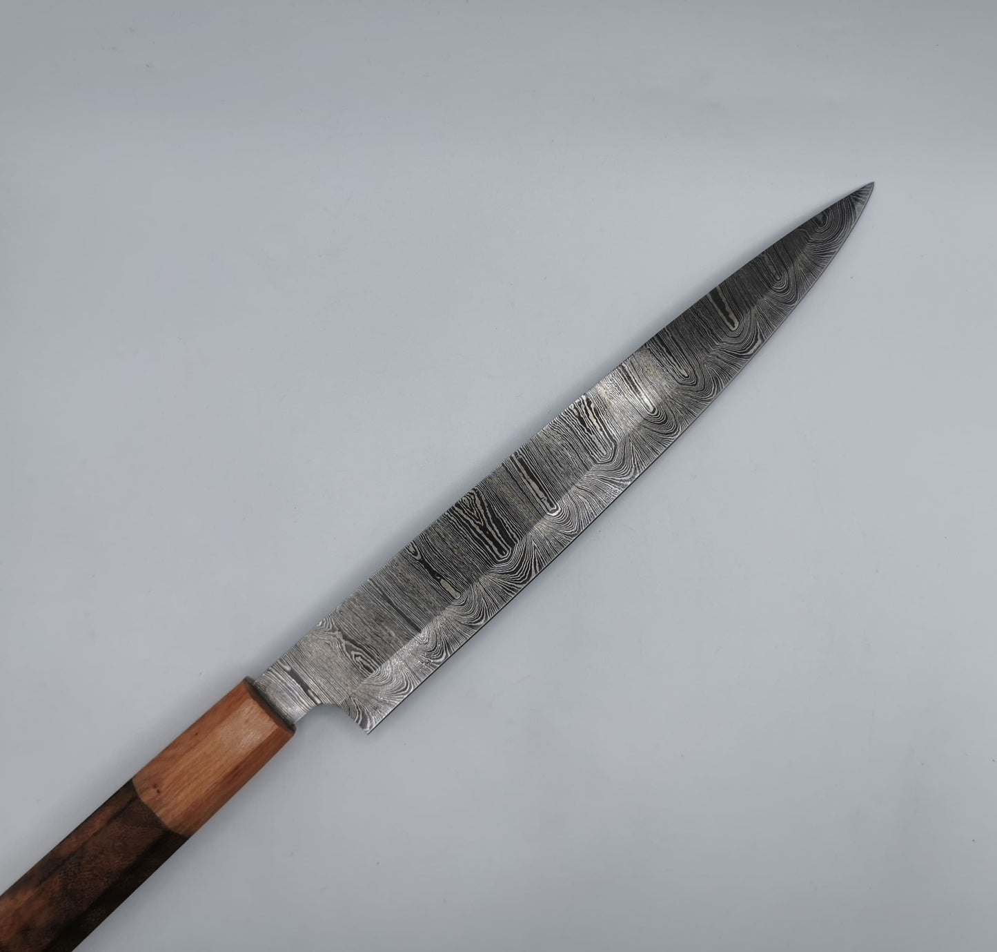 Couteau de chef Hosteel Le Valensola, gros plan sur la lame effilée en acier damas et son talon caractéristique