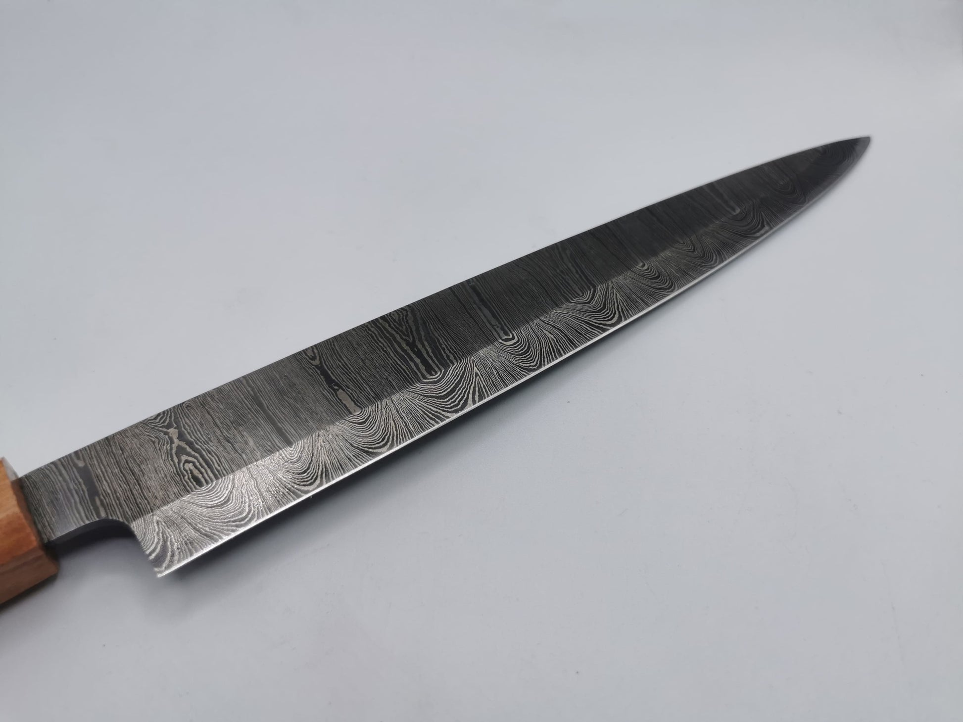 Détail du fil de lame en acier damas trempé à 62 HRC du couteau de chef Le Valensola, tranchant affûté à la main
