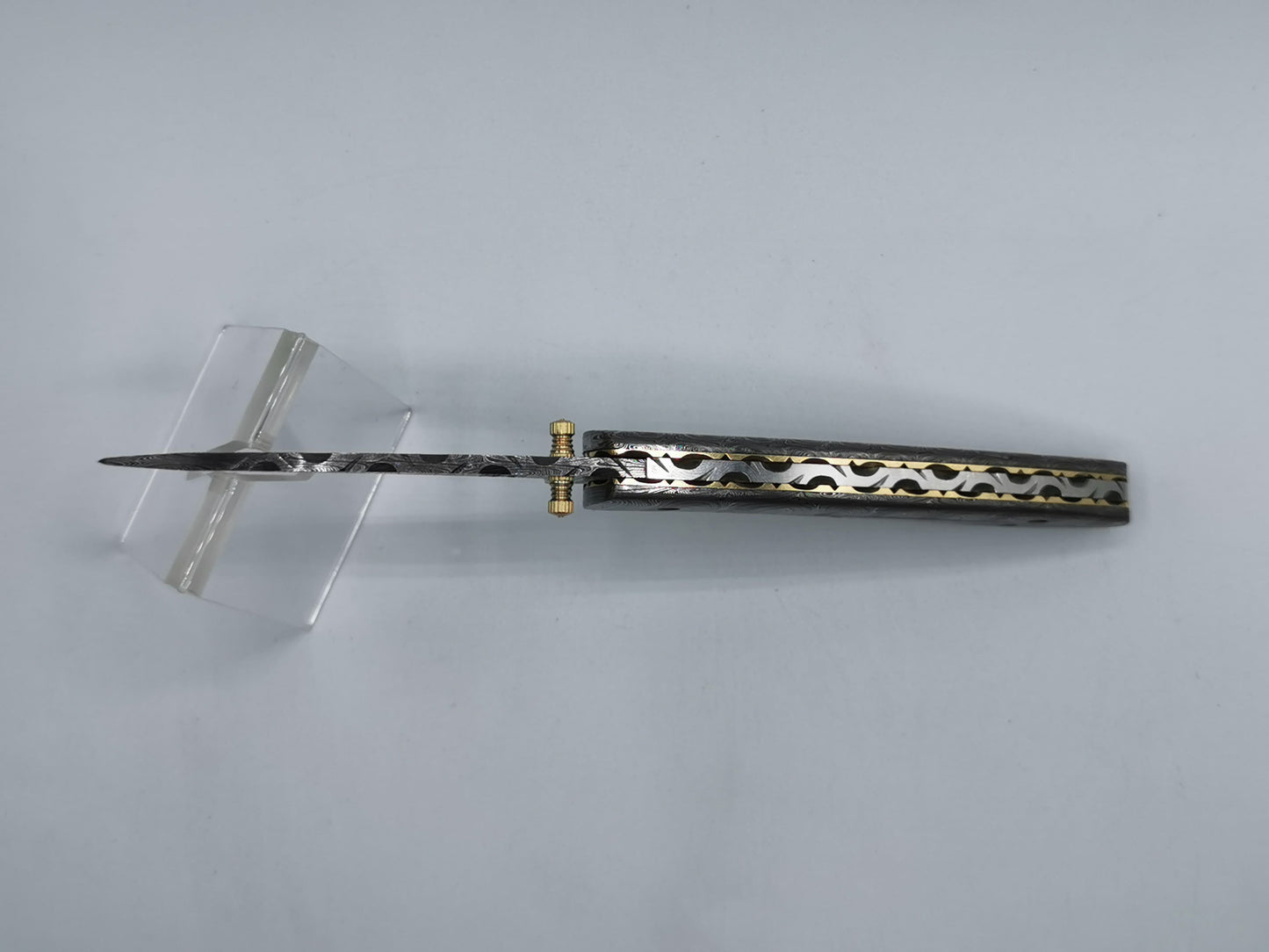 Couteau pliant ouvert L'Alpille vue de dessus dos laiton ajouré style navette
