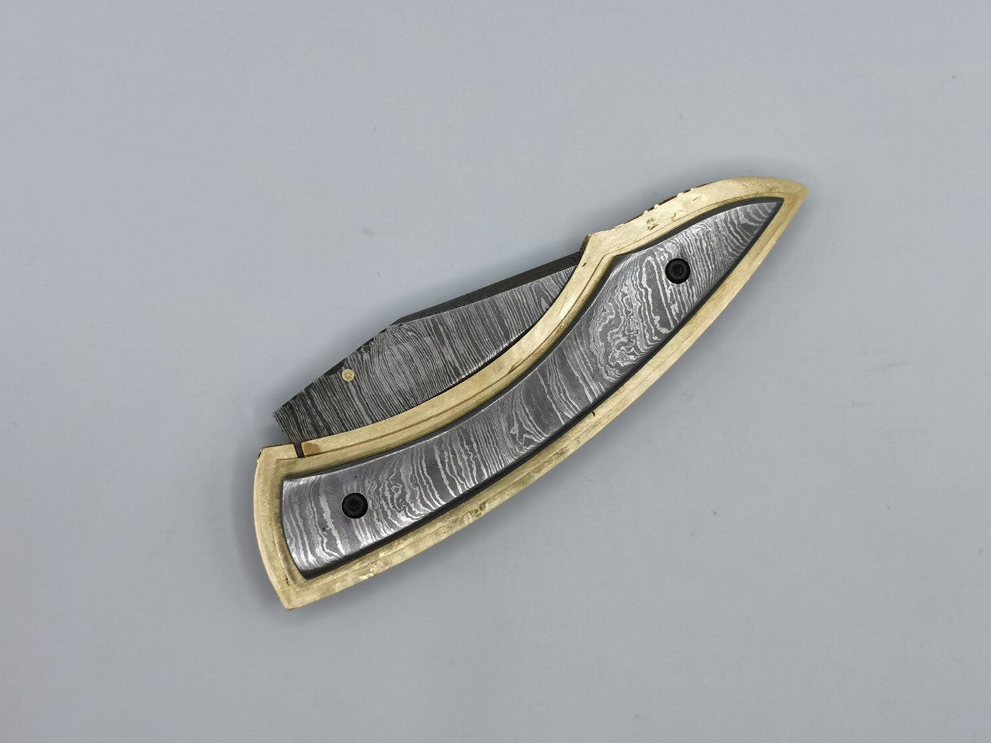 Couteau de poche Le Olympe fermé, vue de dessus, manche acier damas et laiton guilloché coutellerie Hosteel