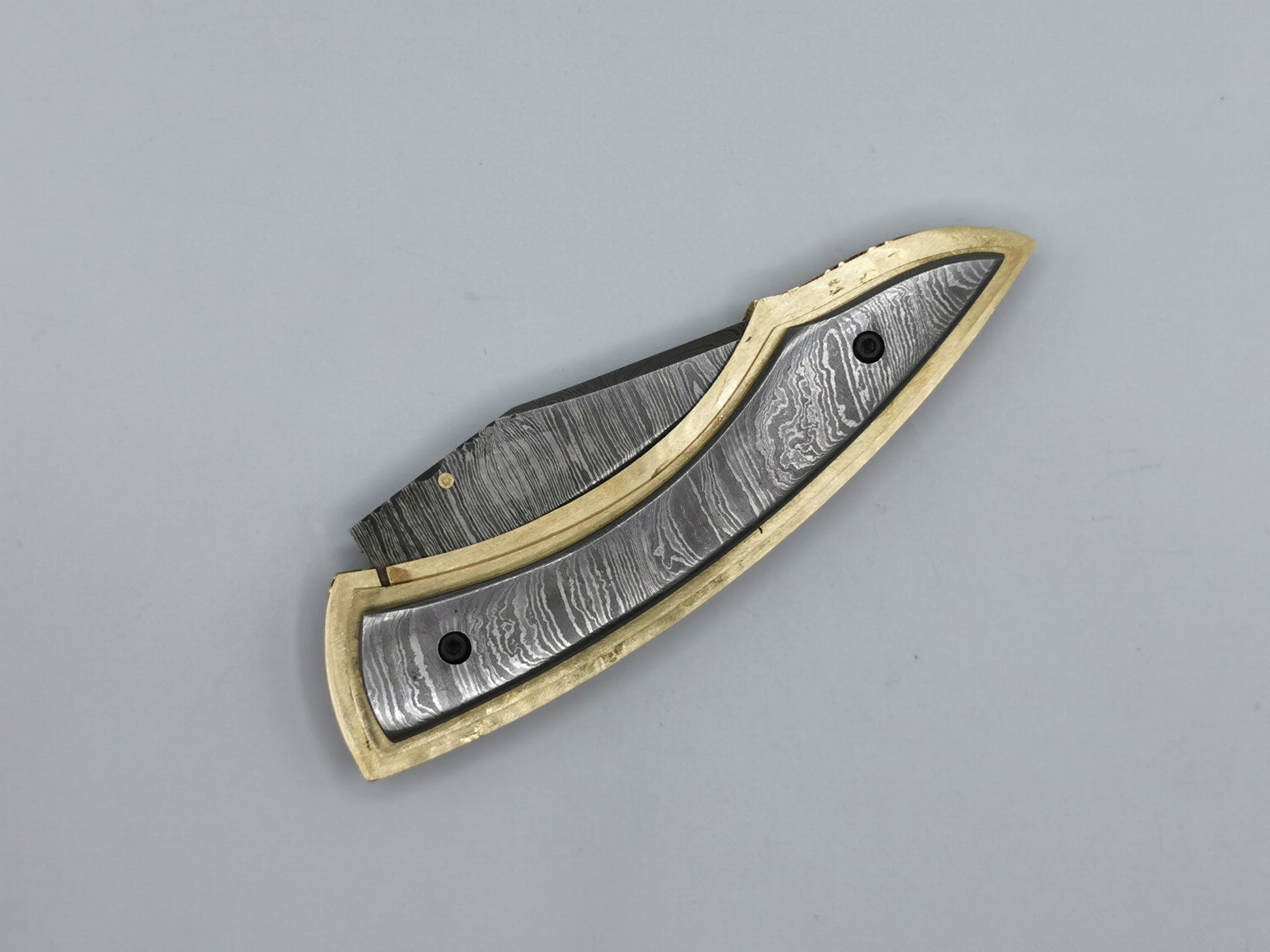 Couteau de poche Le Olympe fermé, vue de dessus, manche acier damas et laiton guilloché coutellerie Hosteel