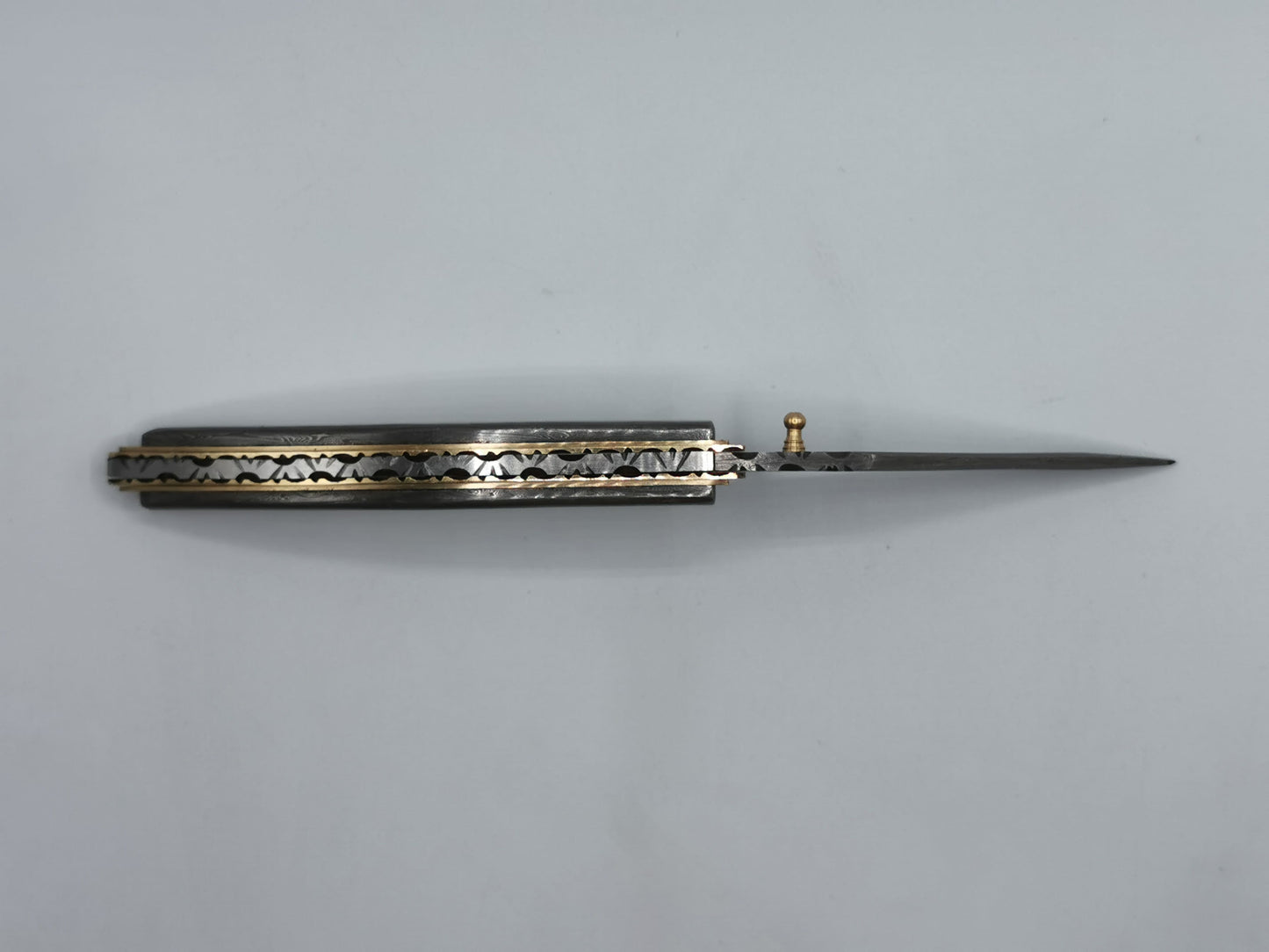 Couteau pliant artisanal Le Olympe ouvert, lame acier damas et manche galbé en laiton