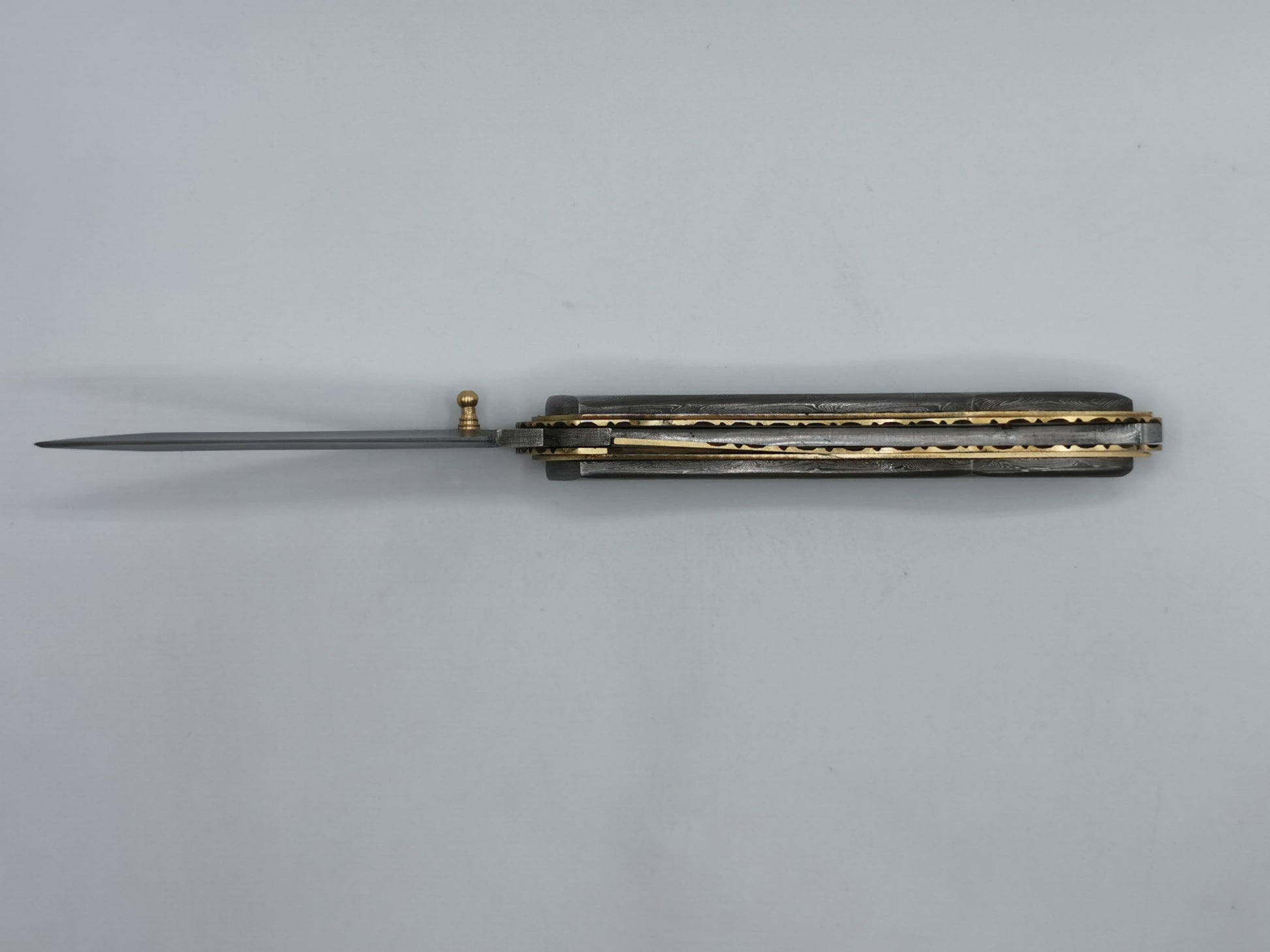 Couteau pliant artisanal Le Olympe ouvert, lame acier damas et manche galbé en laiton de la coutellerie Hosteel