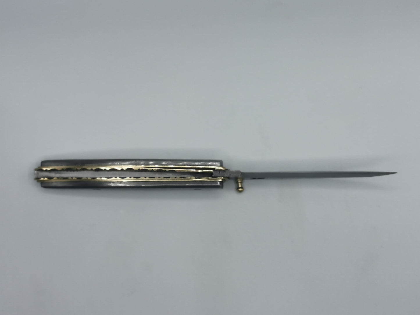 Vue de profil du couteau Le Ferranel ouvert, finitions laiton et acier damas
