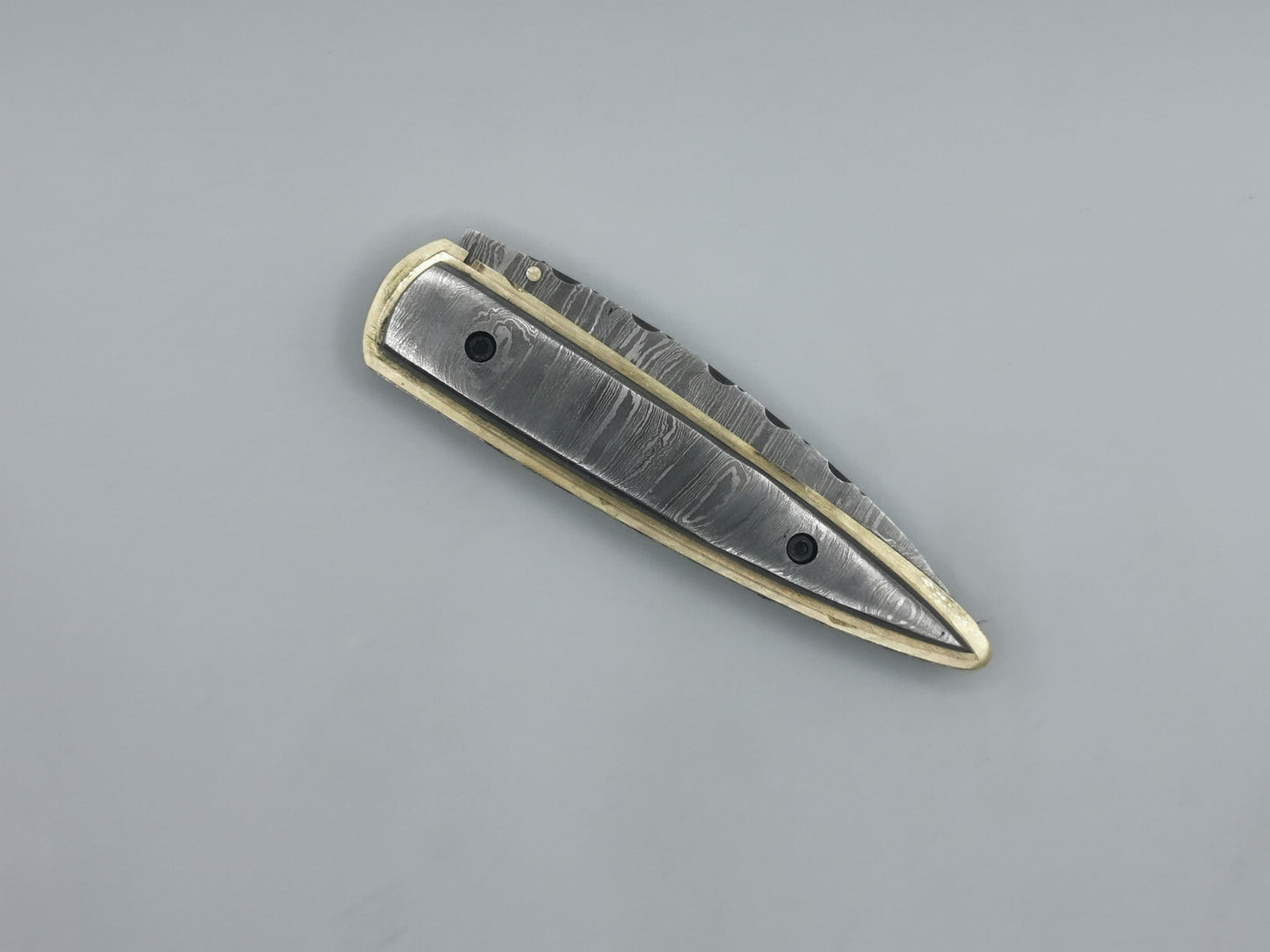 Vue rapprochée de la pointe du manche damas et laiton, couteau Le Ferranel Hosteel