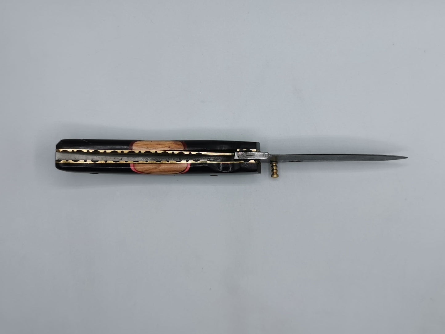 Couteau Le Levan ouvert, vue allongée sur la lame en acier damas et le liseré laiton du manche