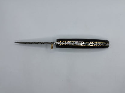 Couteau Le Levan fermé, vue de dessus du manche en corne noire avec liseré laiton ondulé