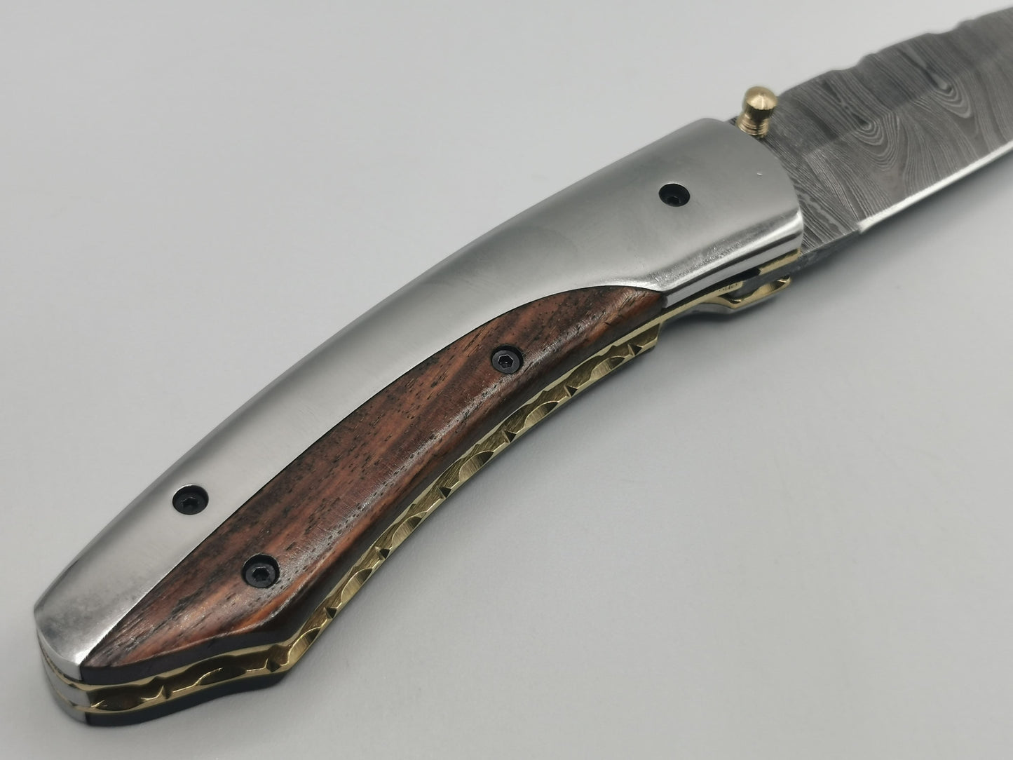 Gros plan sur le talon du manche inox et bois de rose du couteau Le Luberon