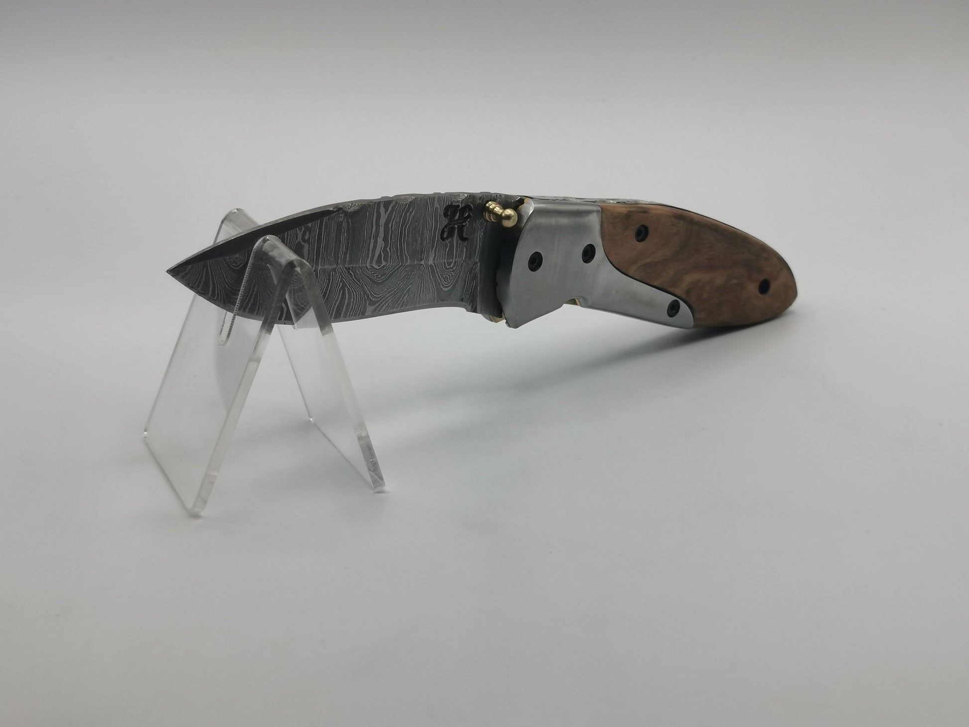 Vue latérale du couteau Le Pagnol sur présentoir, profil chasse et finition inox
