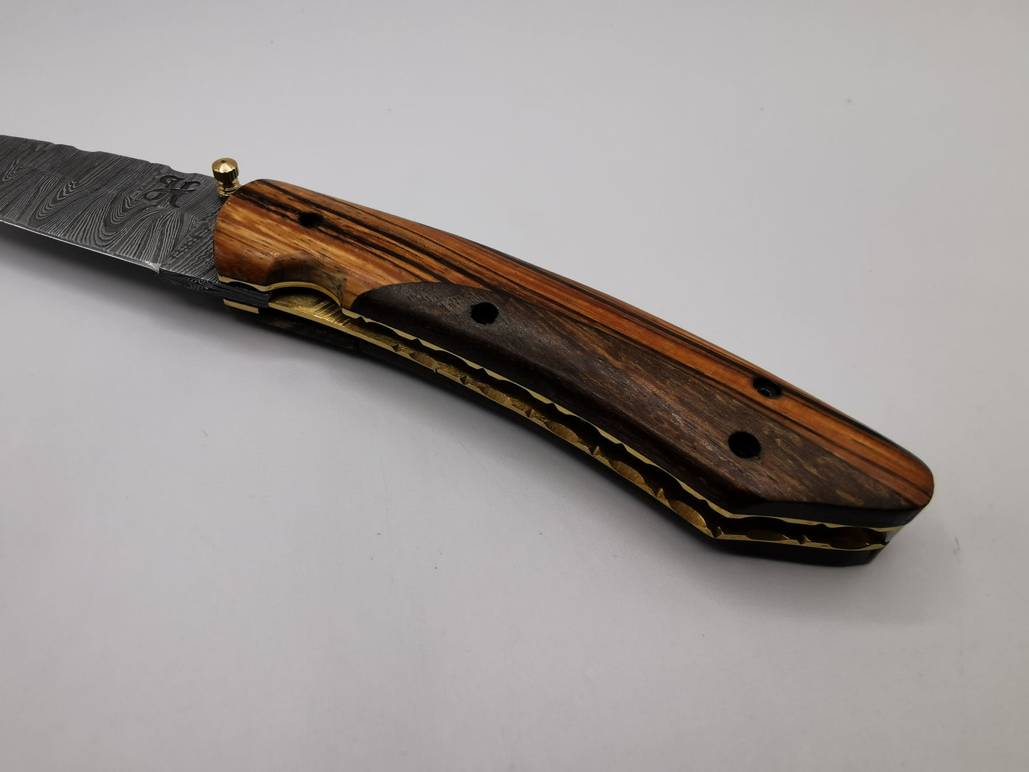Détail du manche en bois de rose et padouk et de la mitre laiton du couteau Le Santonier – Hosteel